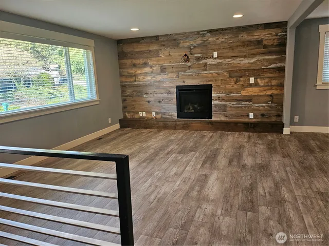 a view of empty room with wooden floor and fireplace