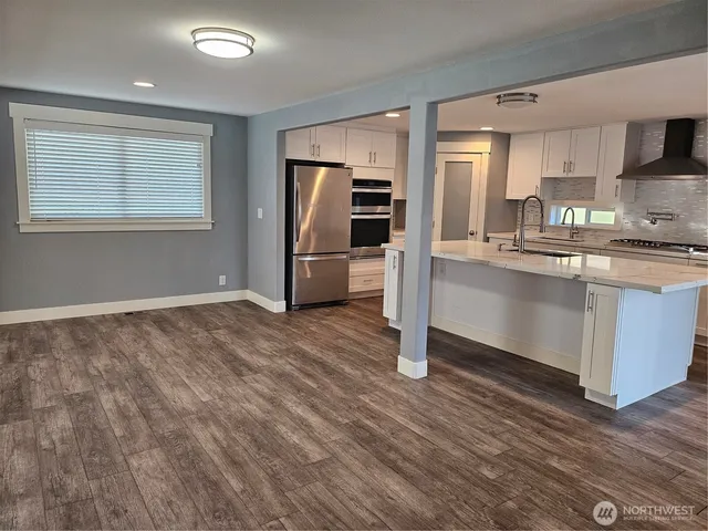 a kitchen with stainless steel appliances granite countertop a stove a sink and a refrigerator
