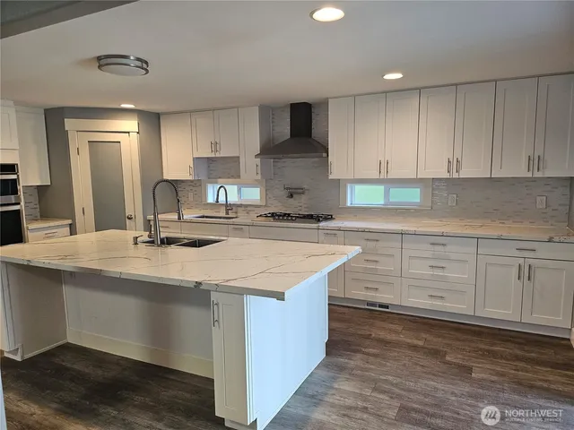 a kitchen with kitchen island granite countertop a sink window and cabinets