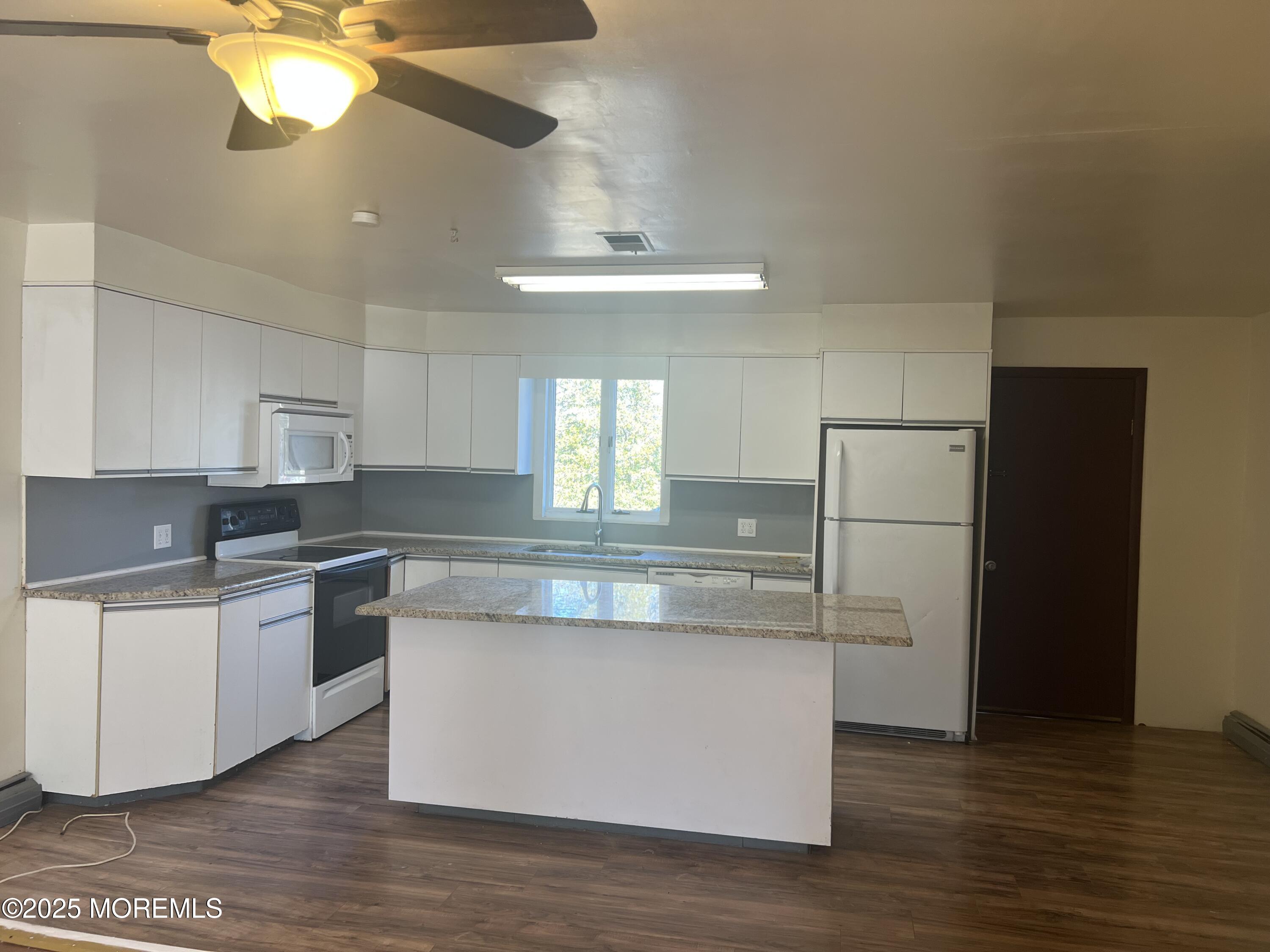 84 Bethany Road Hazlet, NJ 07730 - Photo 6 of 21 a kitchen with stainless steel appliances a refrigerator a sink dishwasher a stove and white countertops with wooden floor