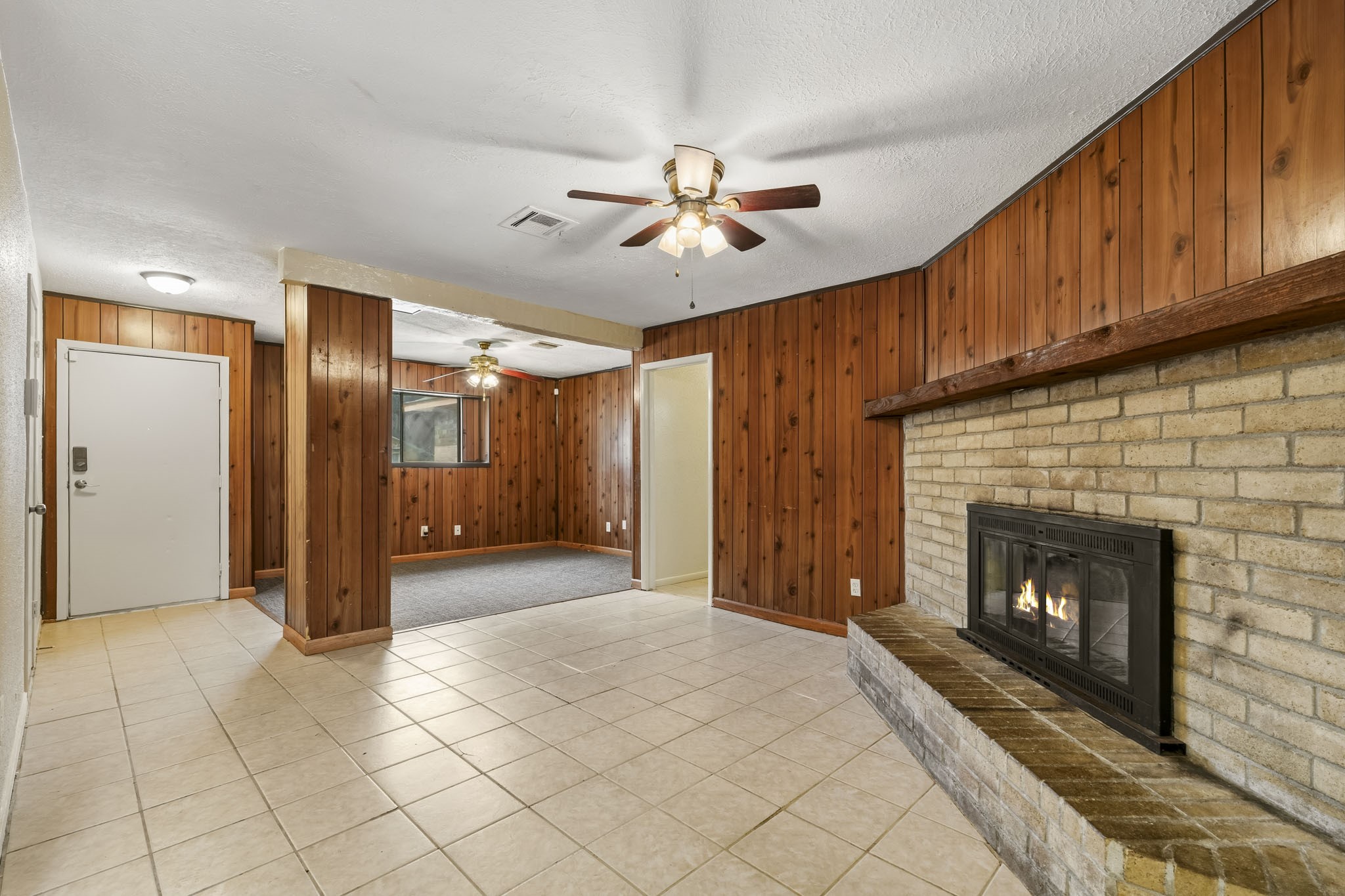 5315 Ridgestone Street Houston, TX 77053 - Photo 11 of 19 Living area with view of hallway leading to the bedrooms featuring a cozy brick fireplace, with an open view into the den.