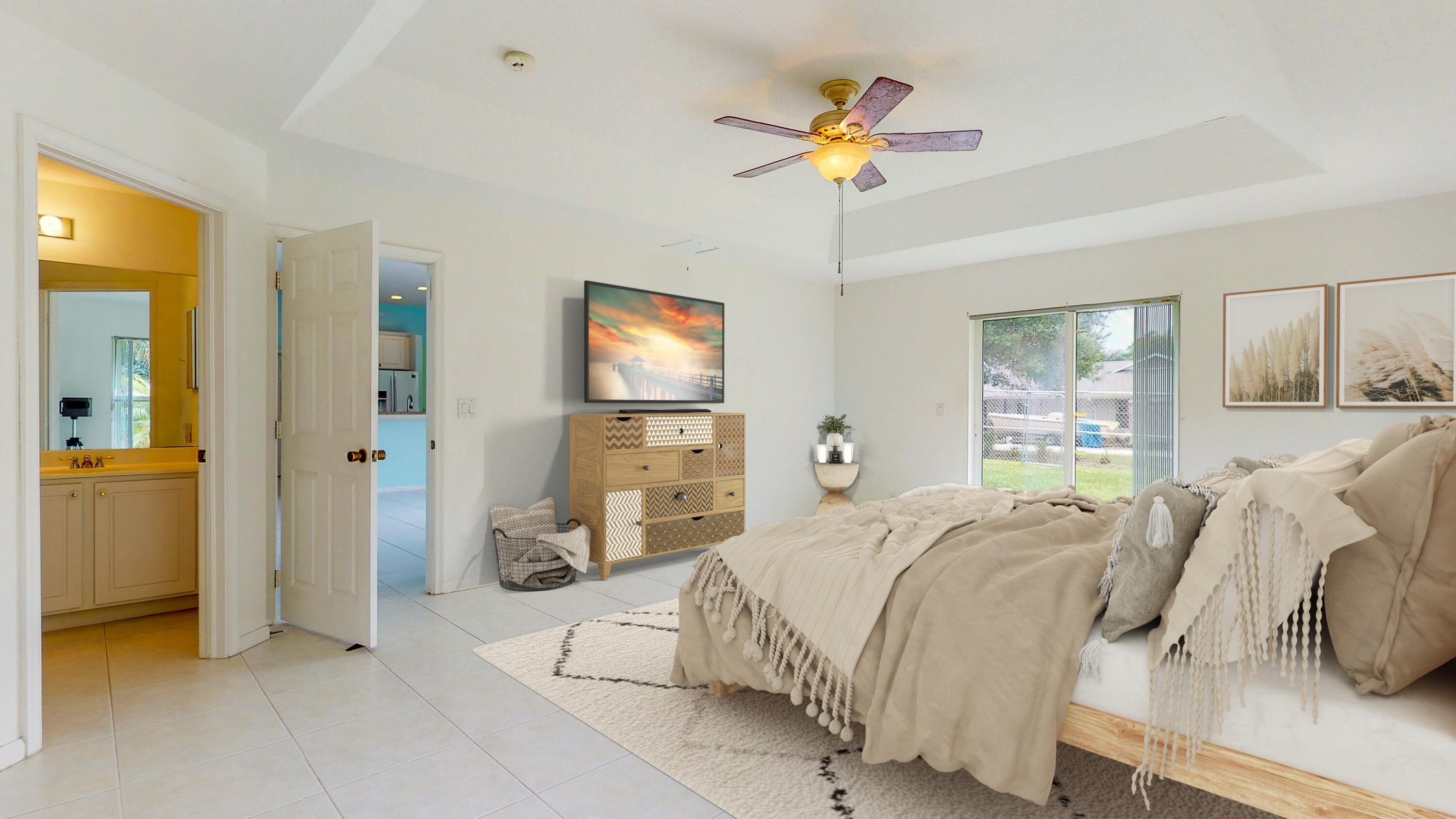 2072 Southeast Hanford Road Port St. Lucie, FL 34952 - Photo 26 of 48 a bedroom with a bed and a chandelier
