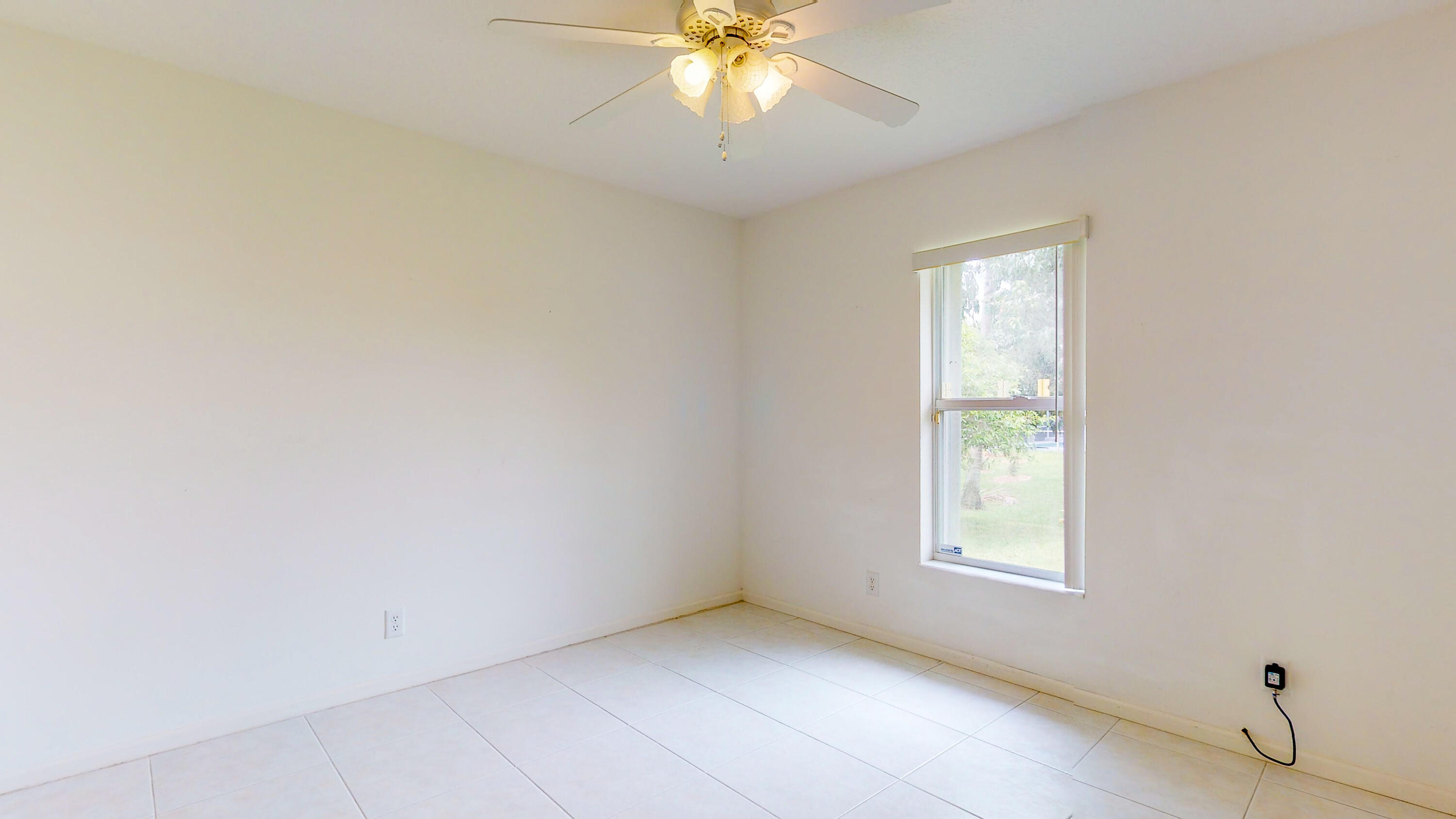 2072 Southeast Hanford Road Port St. Lucie, FL 34952 - Photo 29 of 48 an empty room with a window and a chandelier fan