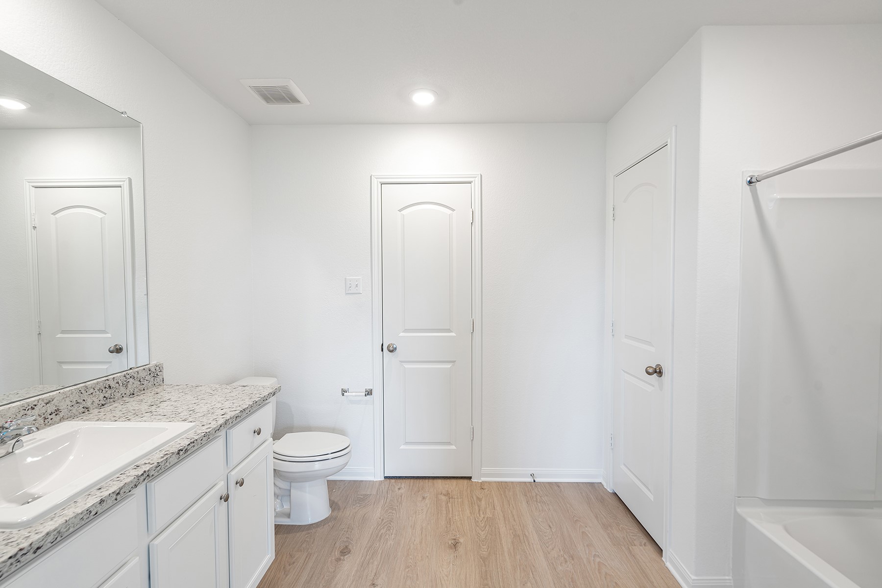 14504 Wahlbergs Way Elgin, TX 78621 - Photo 7 of 10 a bathroom with a granite countertop sink a toilet and shower
