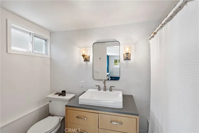 a bathroom with a toilet sink a mirror and vanity