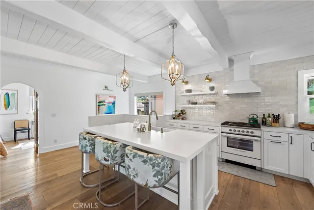 a kitchen with kitchen island a stove a table and chairs in it