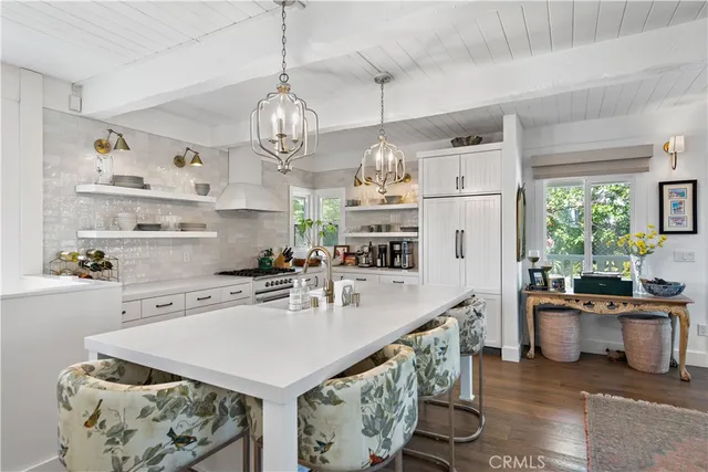 a kitchen with stainless steel appliances granite countertop a sink a stove and a refrigerator