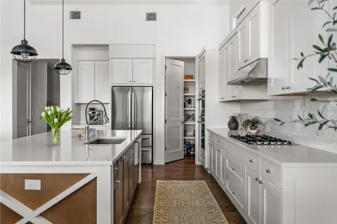 a kitchen with stainless steel appliances kitchen island granite countertop a refrigerator a stove and a sink
