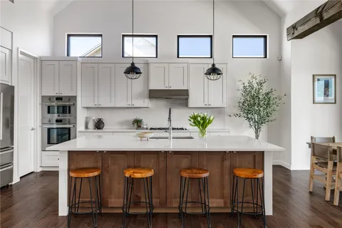 a kitchen with granite countertop a table chairs stove and cabinets