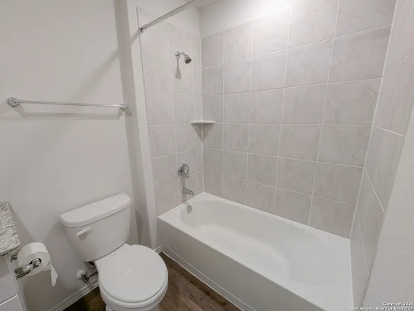 a white toilet sitting next to a bath tub