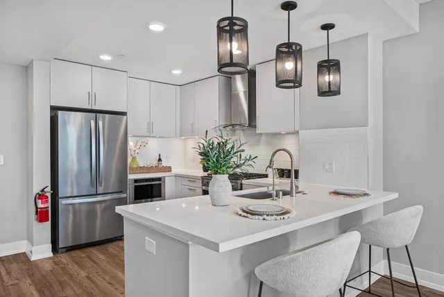 a kitchen with stainless steel appliances kitchen island a refrigerator and a sink