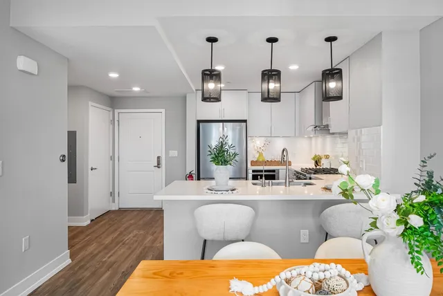 a living room with stainless steel appliances kitchen island granite countertop furniture a rug and a view of kitchen