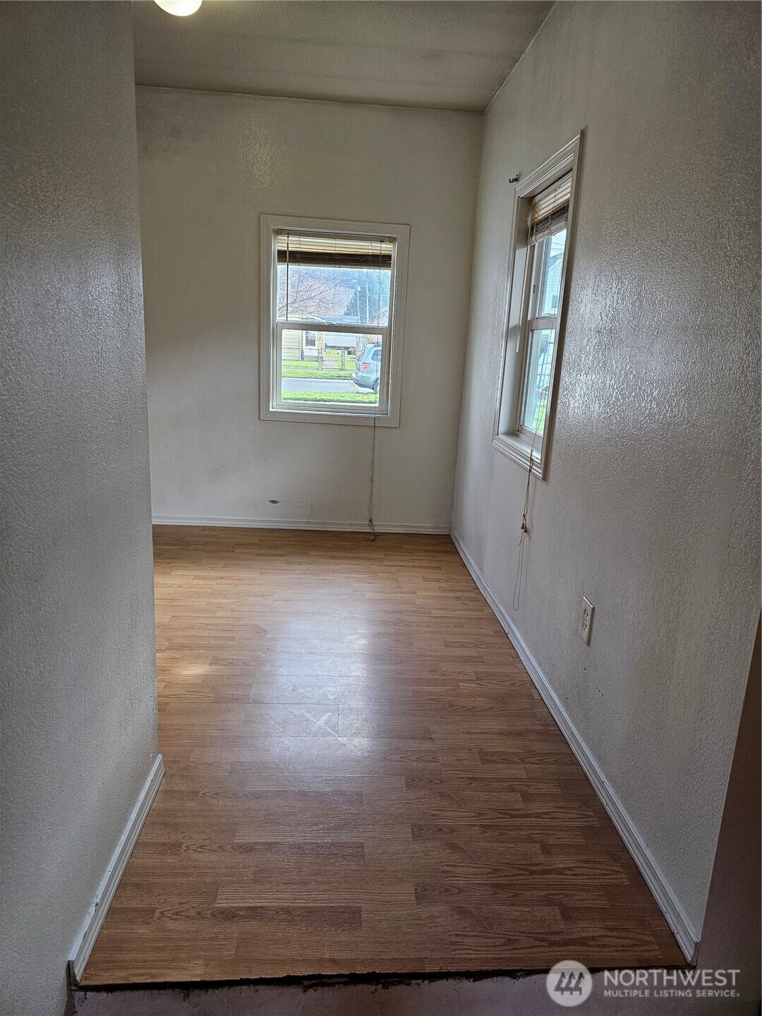 417 Monroe Street Hoquiam, WA 98550 - Photo 9 of 27 an empty room with wooden floor and windows