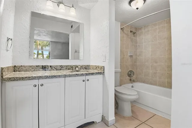 a bathroom with a granite countertop sink a toilet and shower