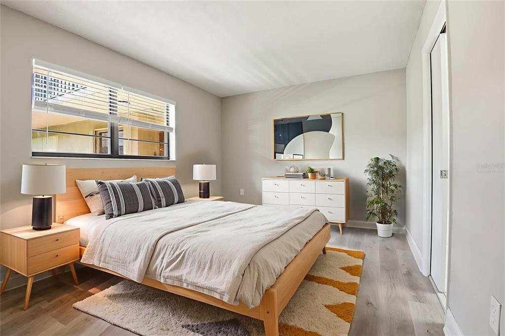 10875 Southwest 112th Avenue, Unit 202 Miami, FL 33176 - Photo 9 of 26 a bed room with a bed and a mirror