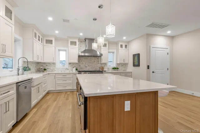 a kitchen with kitchen island a counter top space a sink stainless steel appliances and cabinets