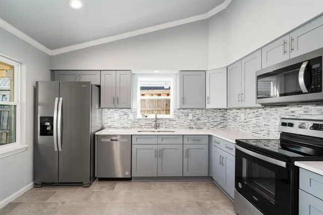 a kitchen with stainless steel appliances granite countertop a refrigerator stove a sink dishwasher and microwave