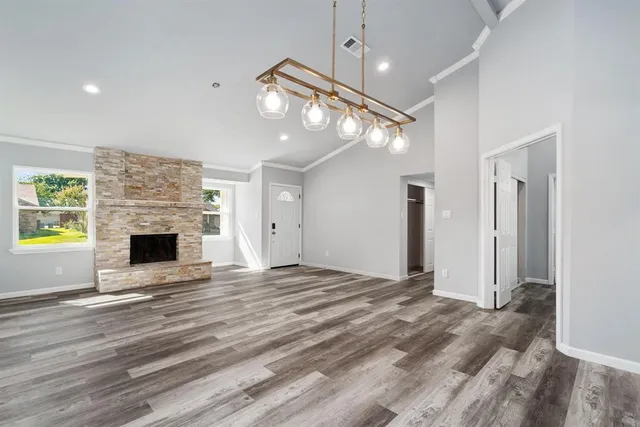 a view of empty room with fireplace and wooden floor