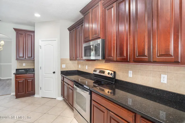 a kitchen with granite countertop cabinets stainless steel appliances and a counter space