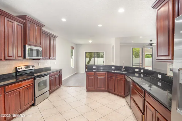 a large kitchen with granite countertop a sink and cabinets