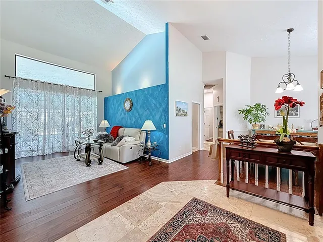 a dining room filled chandelier and kitchen view