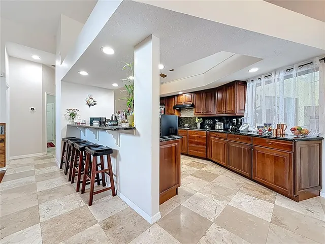 a bathroom with a granite countertop toilet sink and mirror
