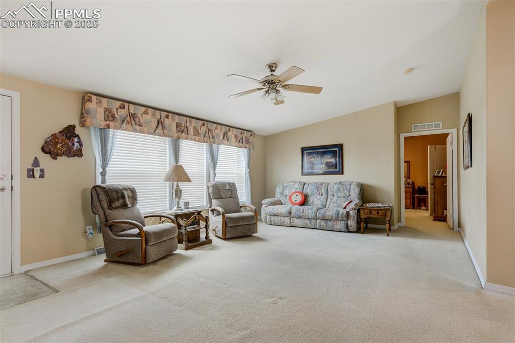 22038 County Road 2 Rush, CO 80833 - Photo 12 of 50 Carpeted living room featuring baseboards, visible vents, vaulted ceiling, and a ceiling fan