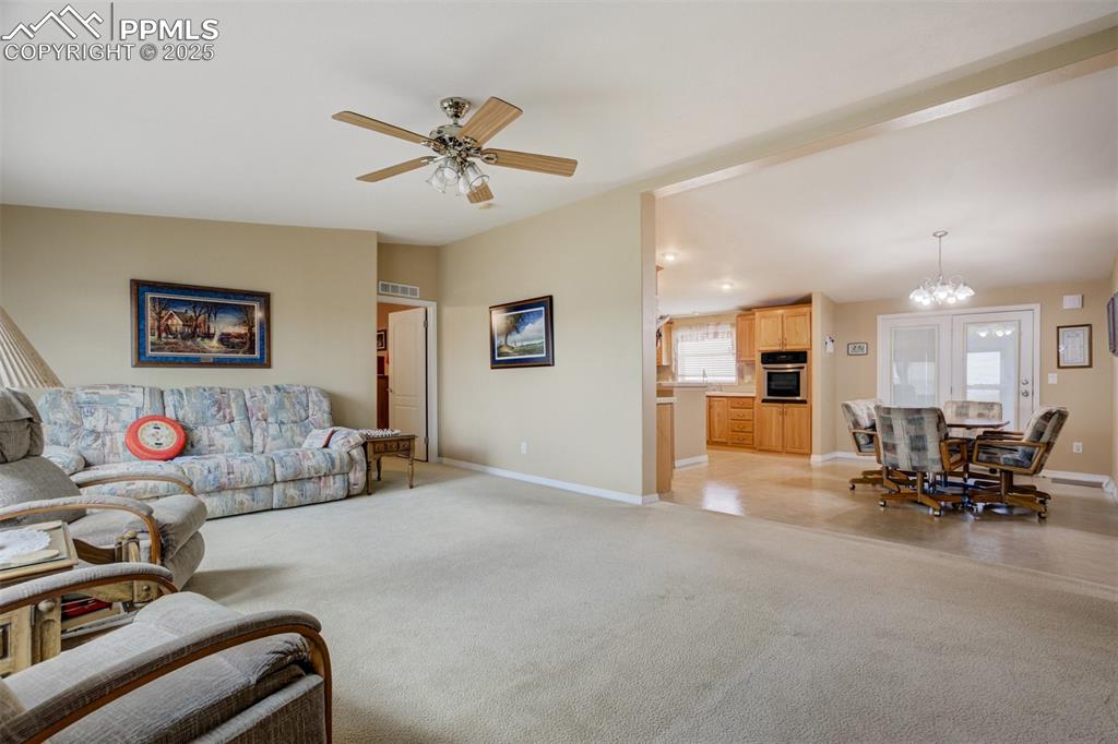 22038 County Road 2 Rush, CO 80833 - Photo 13 of 50 Living area with baseboards, visible vents, vaulted ceiling, and ceiling fan with notable chandelier