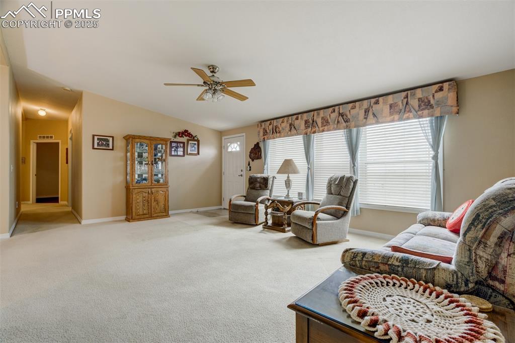 22038 County Road 2 Rush, CO 80833 - Photo 14 of 50 Living room with light colored carpet, lofted ceiling, ceiling fan, and baseboards