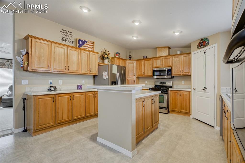 22038 County Road 2 Rush, CO 80833 - Photo 17 of 50 Kitchen with light countertops, a kitchen island, stainless steel appliances, and light floors