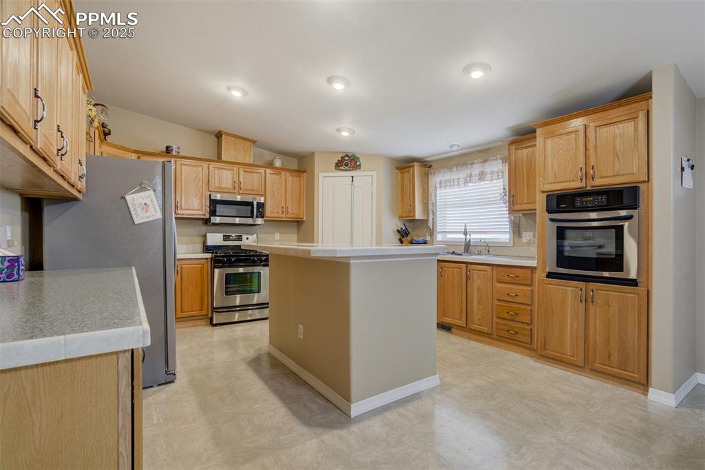 22038 County Road 2 Rush, CO 80833 - Photo 18 of 50 Kitchen featuring light countertops, stainless steel appliances, a center island, and light floors