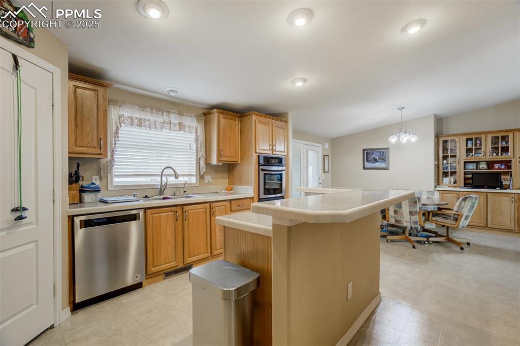 22038 County Road 2 Rush, CO 80833 - Photo 20 of 50 Kitchen featuring light countertops, a sink, light floors, appliances with stainless steel finishes, and a center island