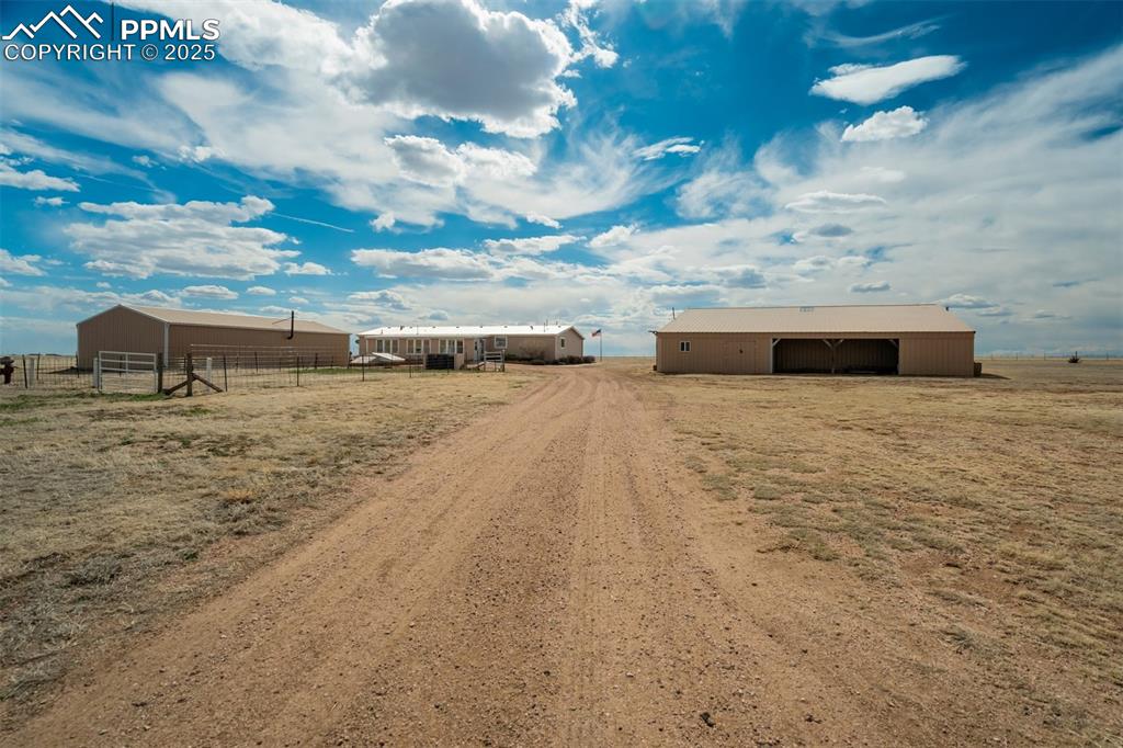 22038 County Road 2 Rush, CO 80833 - Photo 2 of 50 View of street featuring driveway, a rural view, and a pole building