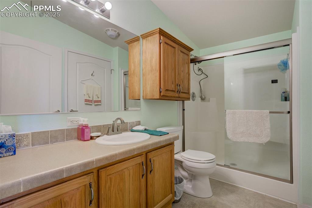 22038 County Road 2 Rush, CO 80833 - Photo 35 of 50 Full bath with toilet, vanity, vaulted ceiling, and a shower stall