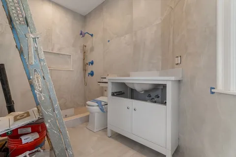 a bathroom with a sink a toilet and shower