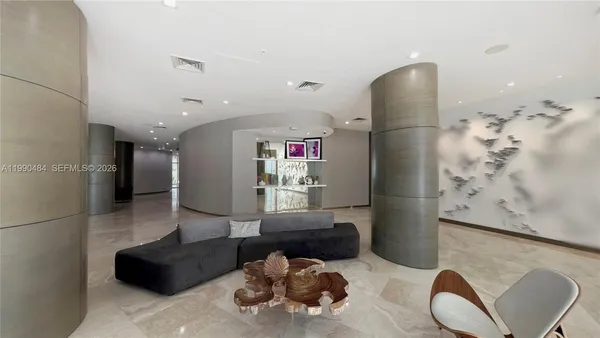 a kitchen with stainless steel appliances granite countertop a refrigerator and a couch