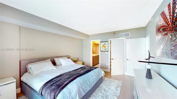 a bedroom with a bed and a large mirror