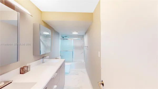 a bathroom with a tub sink and mirror