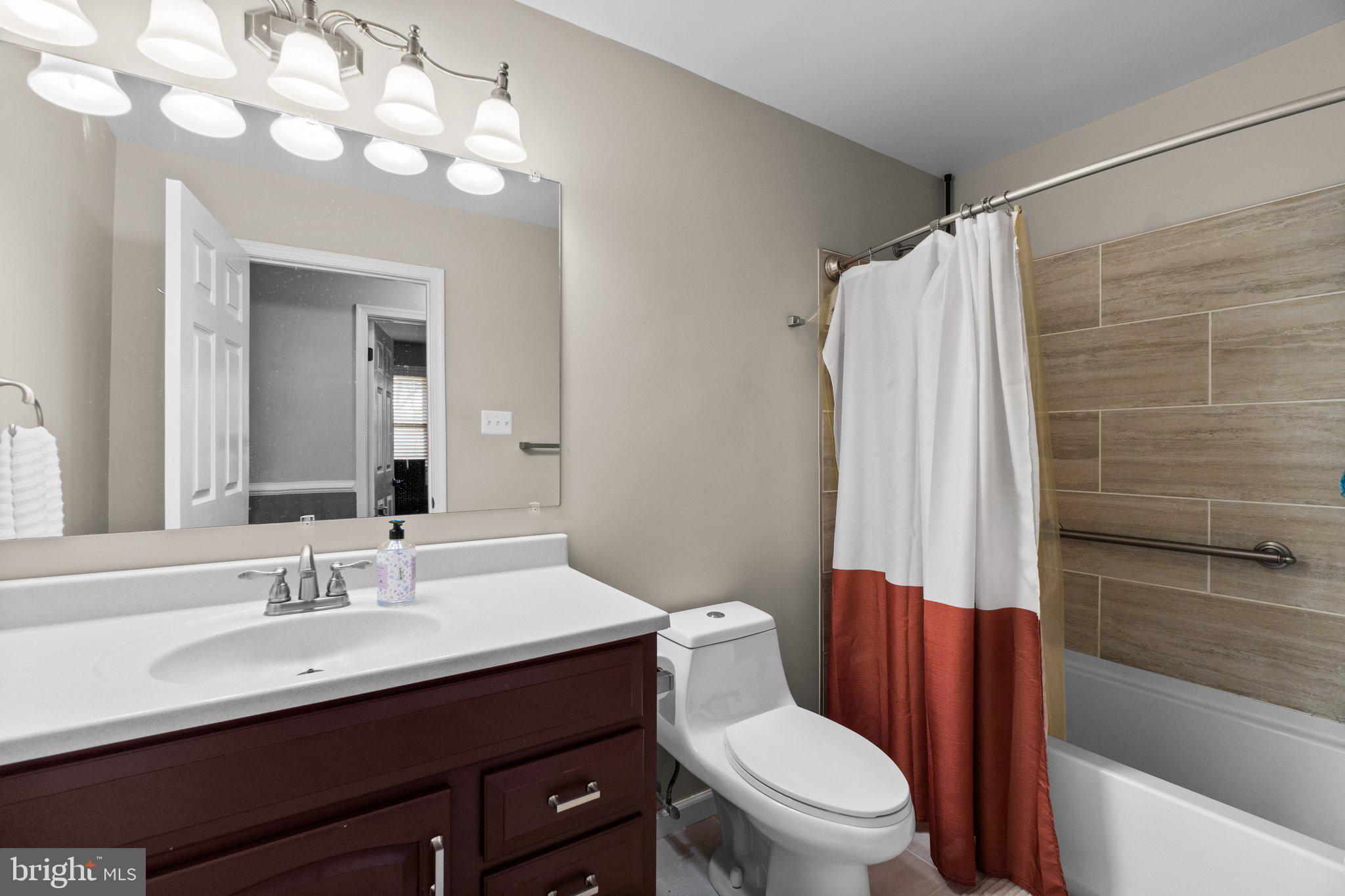 4701 Gross Mill Road Hampstead, MD 21074 - Photo 31 of 62 a bathroom with a sink a toilet a mirror a vanity and shower