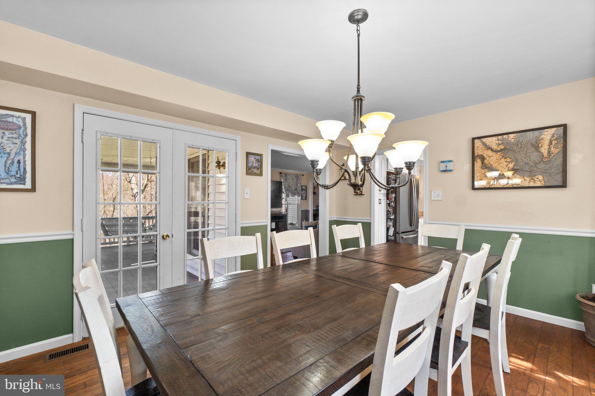 4701 Gross Mill Road Hampstead, MD 21074 - Photo 5 of 62 a dining room with wooden floor a chandelier a wooden table and chairs
