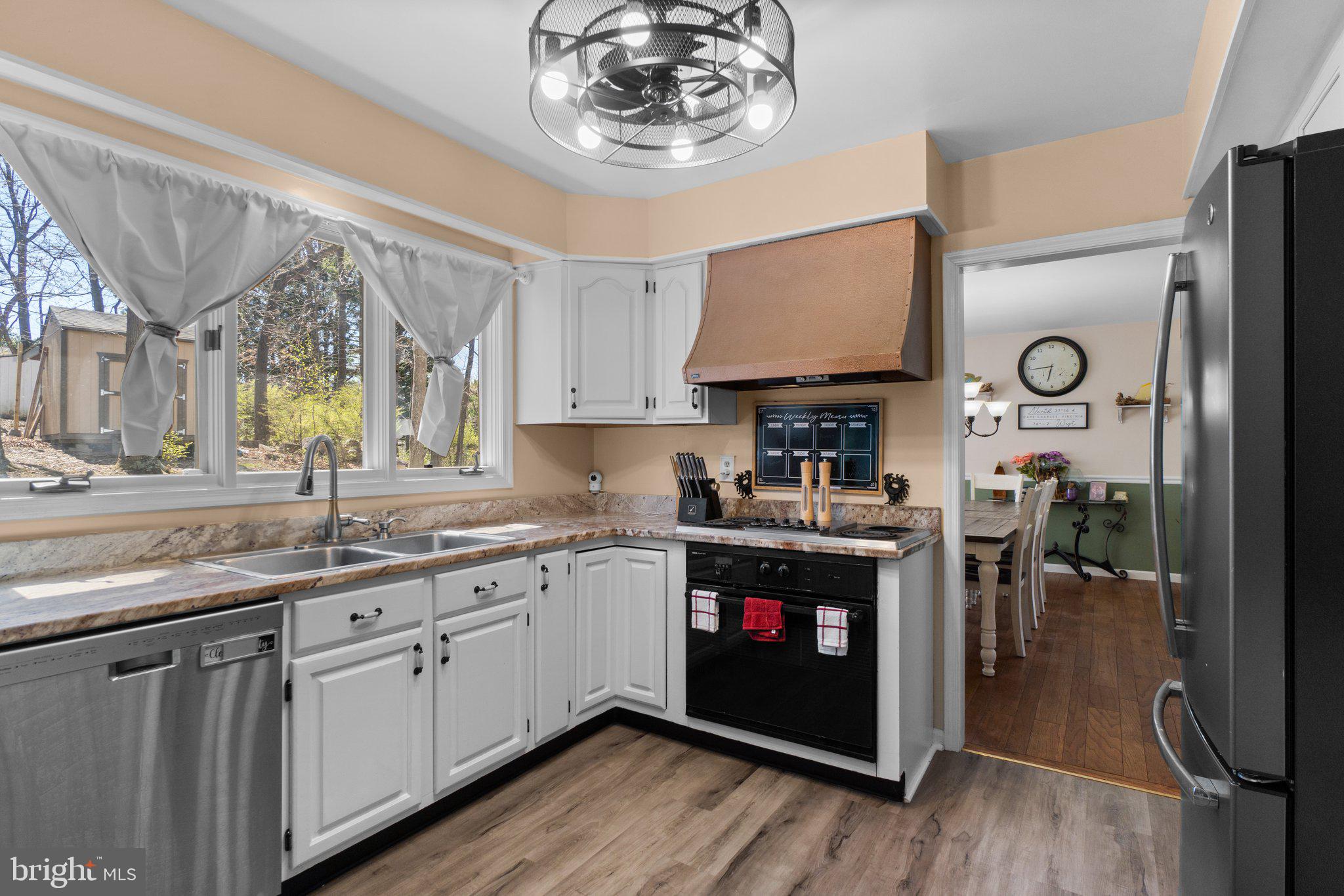 4701 Gross Mill Road Hampstead, MD 21074 - Photo 6 of 62 a kitchen with stainless steel appliances granite countertop a stove a sink dishwasher and a refrigerator with wooden floor