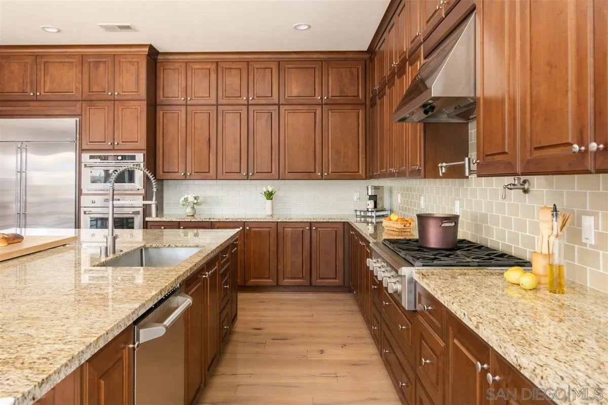 1309 Malone Court Escondido, CA 92026 - Photo 7 of 39 a kitchen with kitchen island granite countertop a sink a counter top space and cabinets