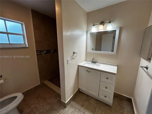 a bathroom with a double vanity sink toilet and mirror