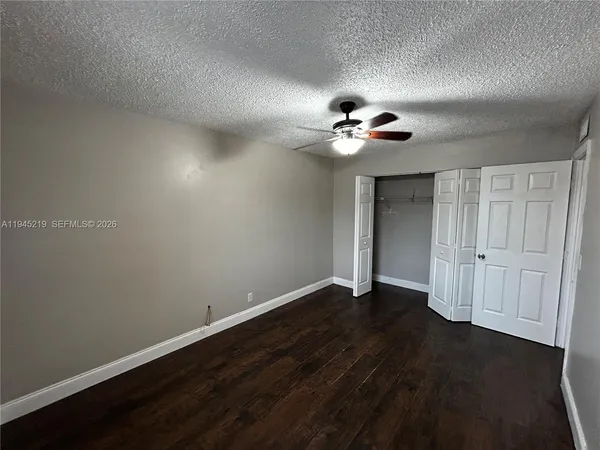 a view of an empty room with a chandelier fan