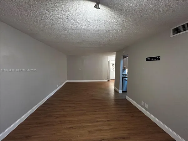a view of an empty room with wooden floor