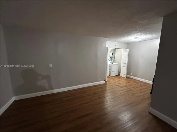 a view of empty room with wooden floor