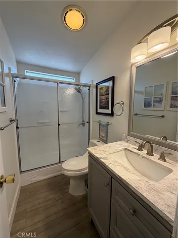 a bathroom with a granite countertop sink toilet and shower