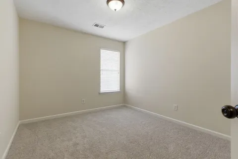 an empty room with a window and a ceiling fan