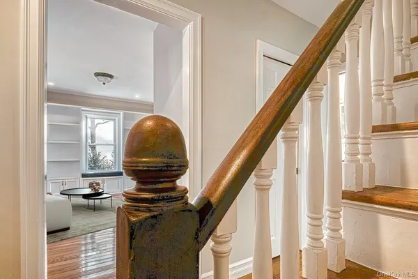 a view of a hallway with wooden floor and staircase