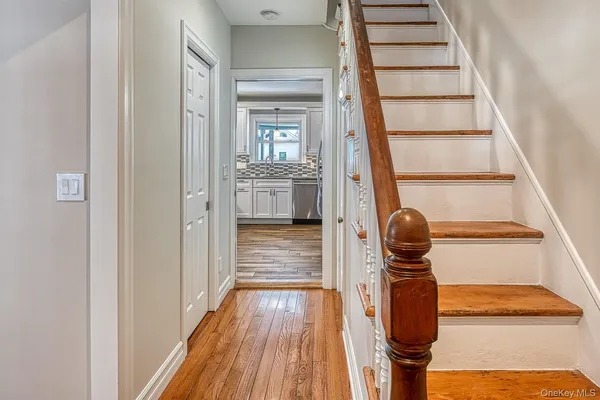 a view of entryway and hall with wooden floor